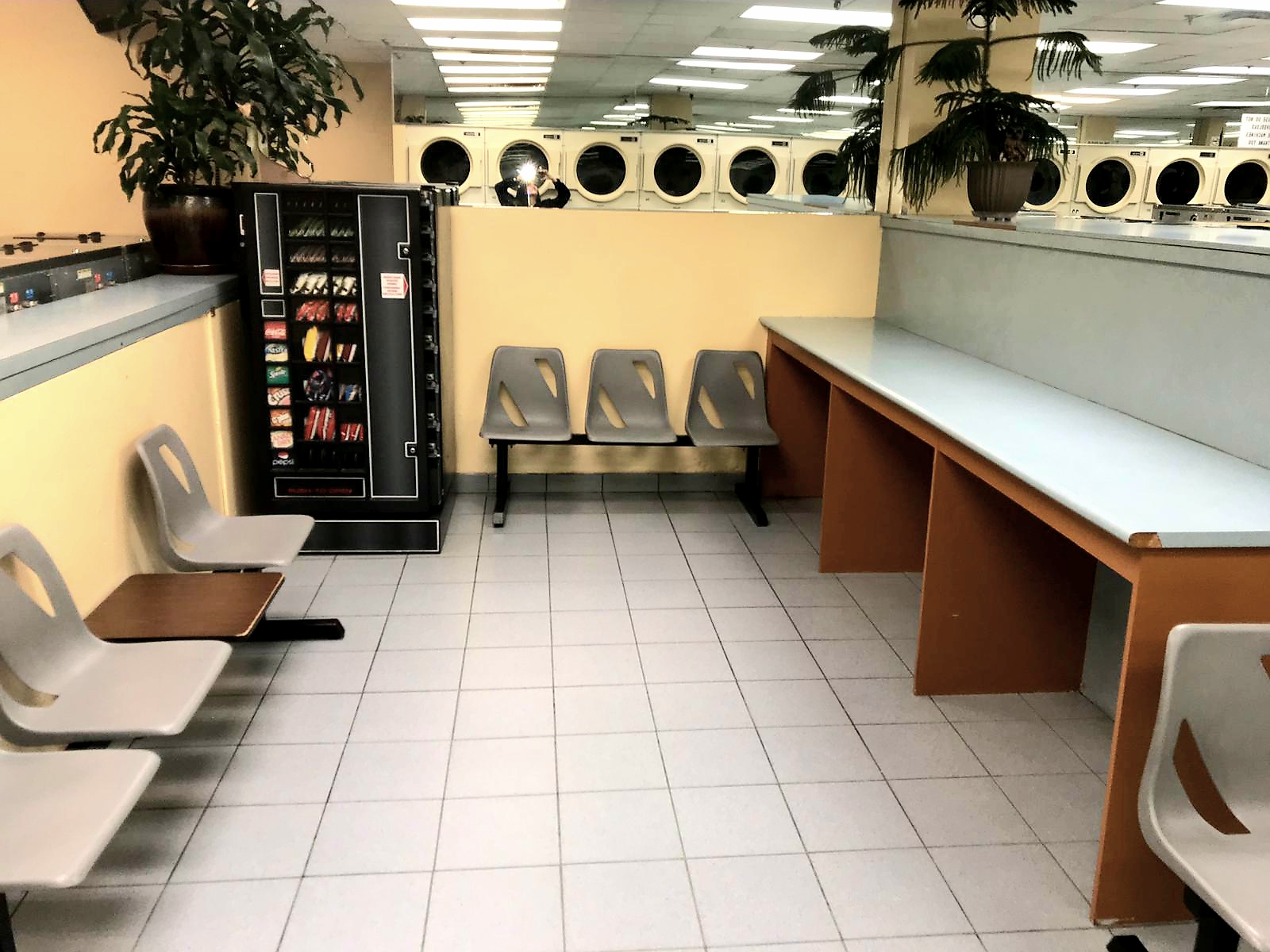 Interior of York U Coin Laundry showing clean seating area, folding counters, and rows of dryers